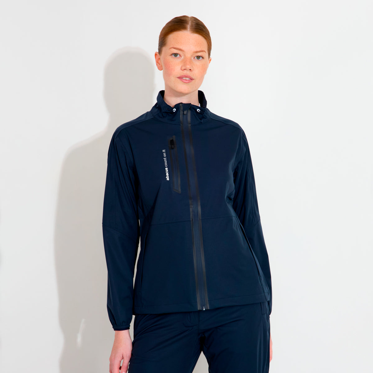 Dame Abacus Bounce regnjakke in vibrant color displayed on a model, showcasing waterproof fabric and adjustable features.