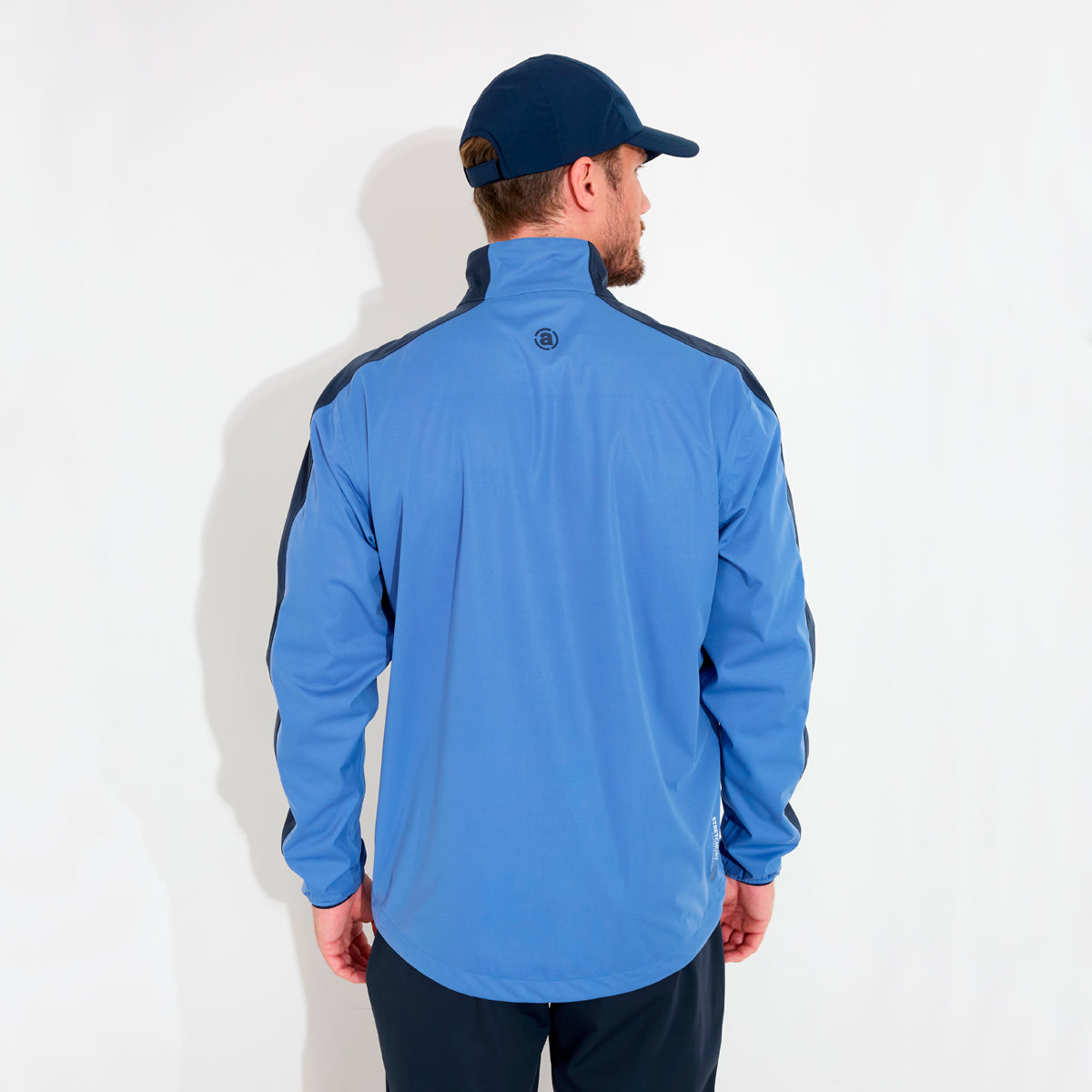 Abacus men's Abacus Bounce rain jacket in blue, showcasing waterproof fabric and adjustable hood in outdoor setting.