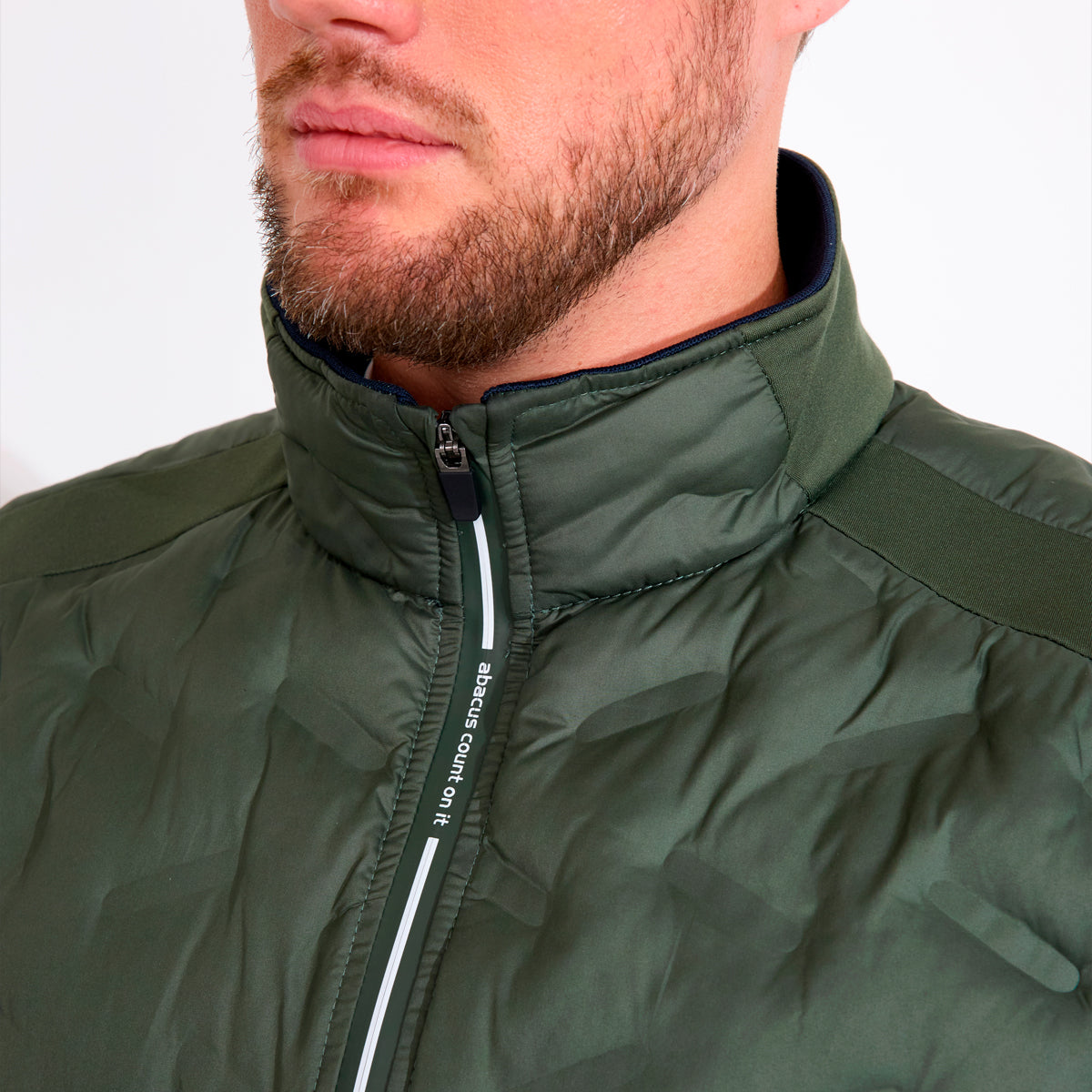 Herre hybrid vest fra Abacus Portrush med quiltet design og stand-up krave, vises i et naturmotif.